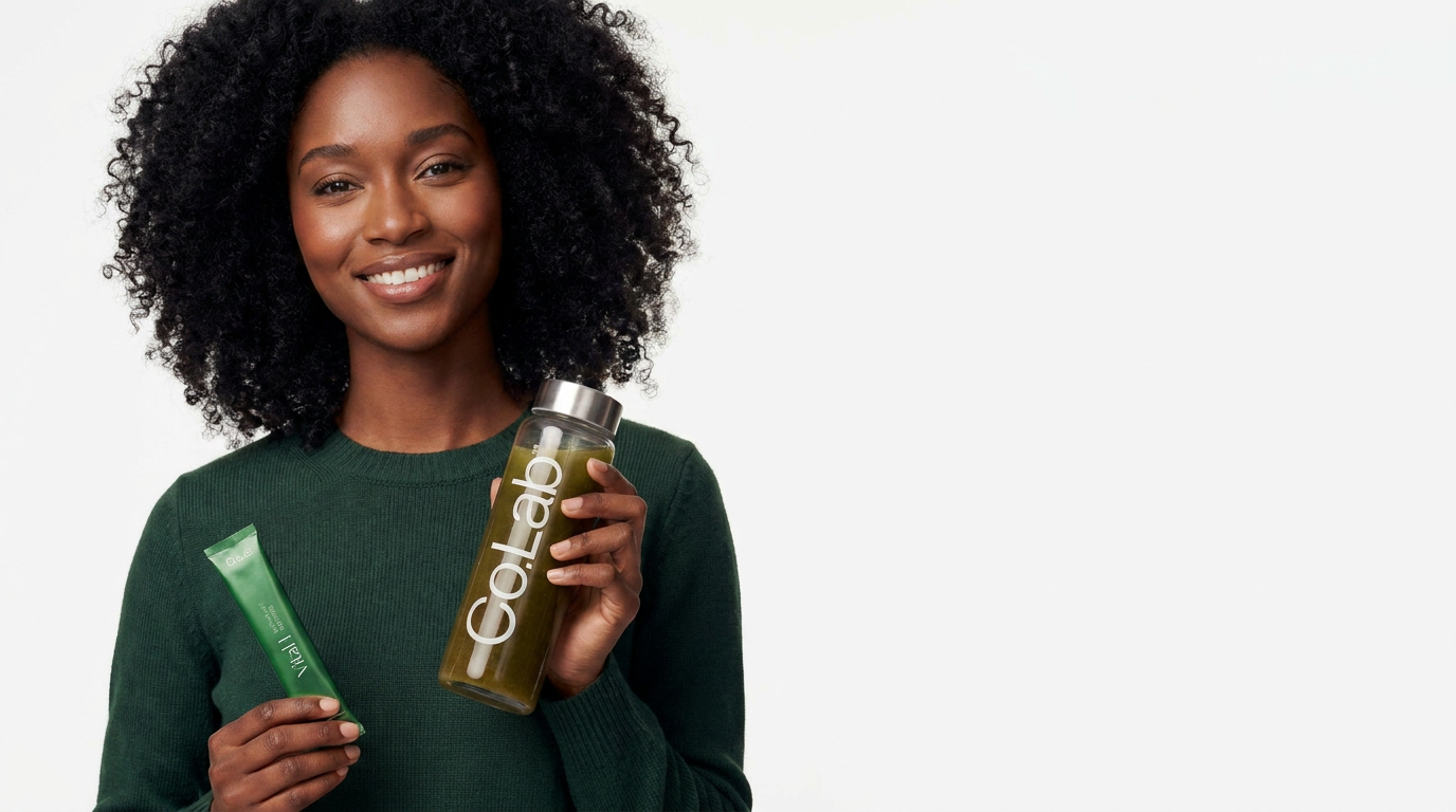 Smiling woman holding a Moringa.co Vital 1 sachet and bottle of green moringa drink